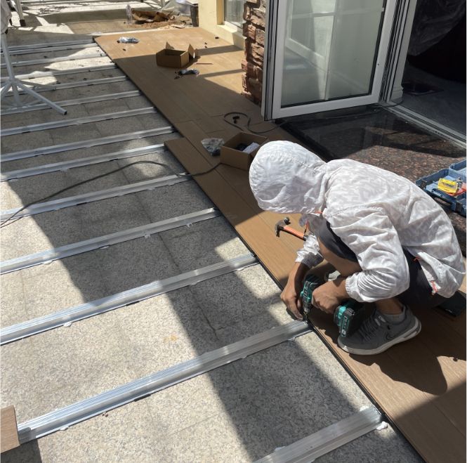 Contractor installing MexyTech WPC decking on aluminum joists using proper composite decking installation and spacing techniques in a residential patio